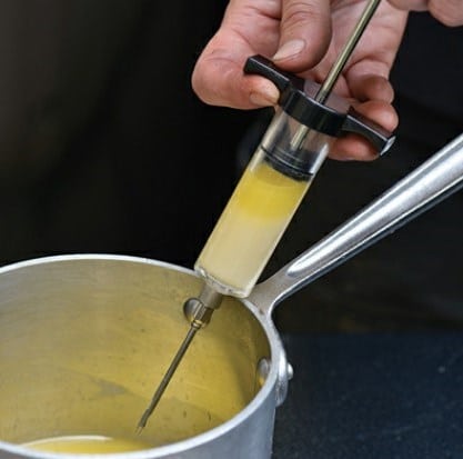 Pull back the plunger to load the injector with melted butter, broth, or liquid flavorings.